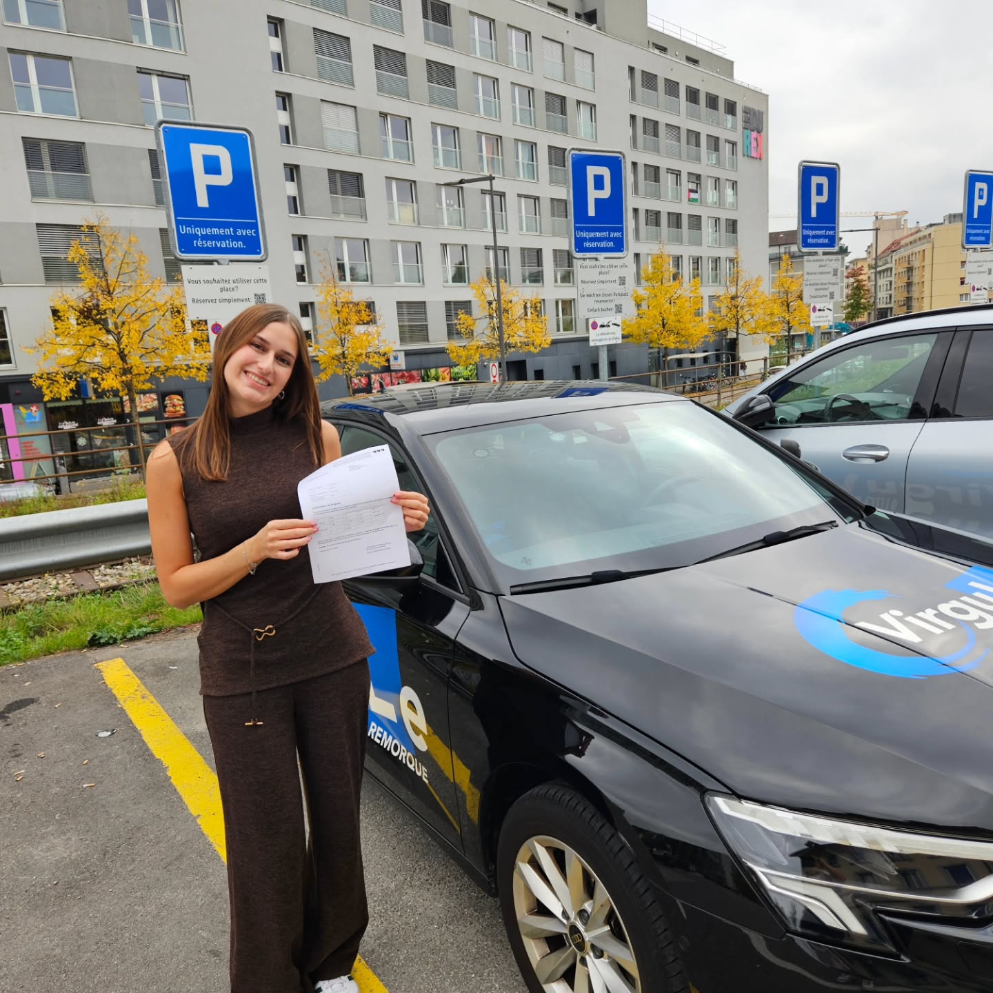 Ophélie, permis voiture en poche, devant la voiture-école Virgule