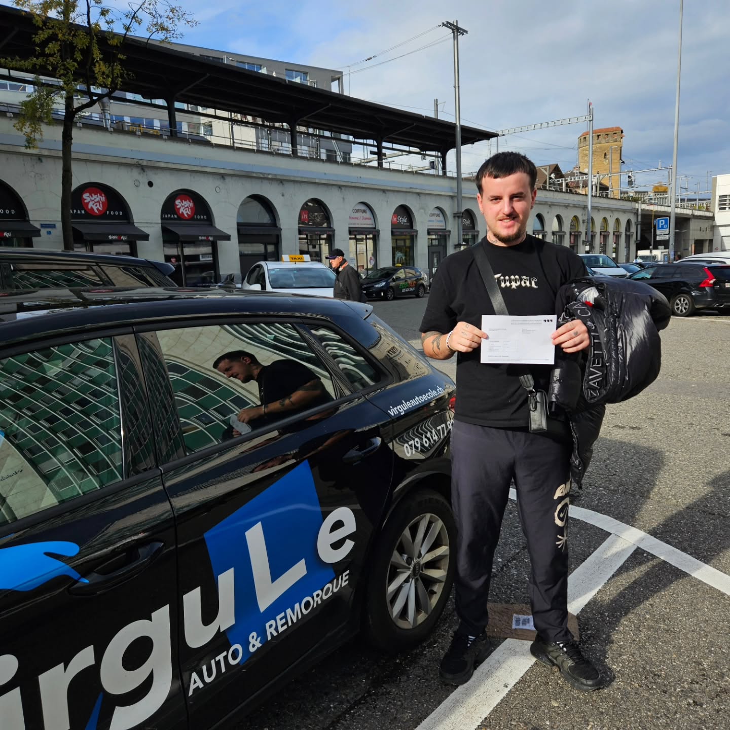 Ruiz, permis obtenu, devant la voiture-école Virgule