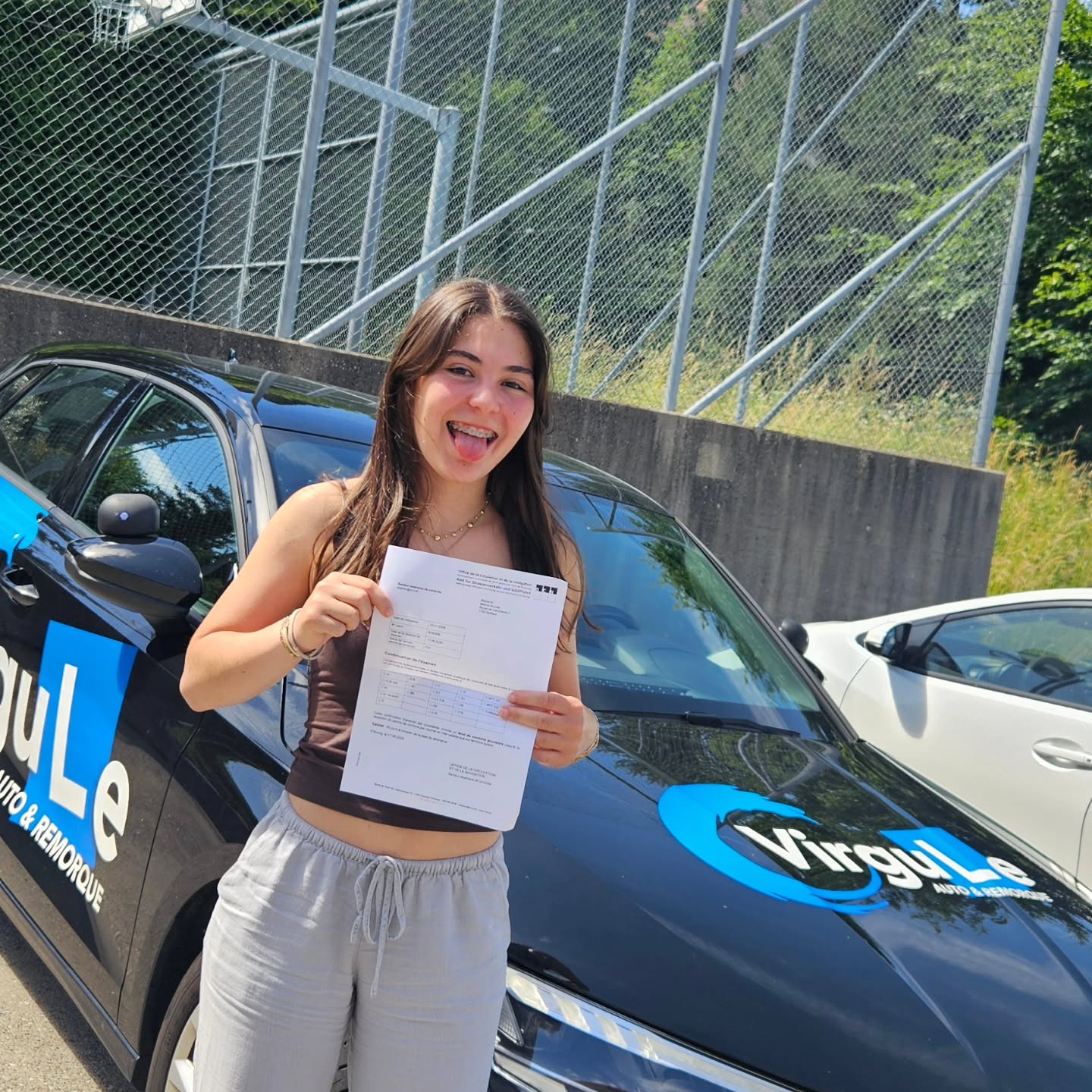 Méline, permis en poche, devant la voiture-école Virgule